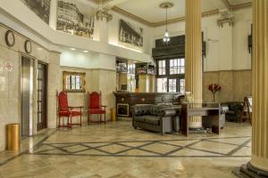 een lobby met een bank, stoelen en een tafel bij Atlântico Hotel in Santos