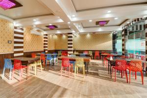 a restaurant with colorful chairs and tables in a room at Hotel O Mini Punjab Hills in Jamshedpur