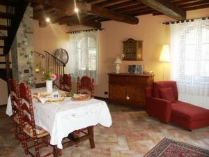 a living room with a table and a red chair at La Morosa in Castel Rigone