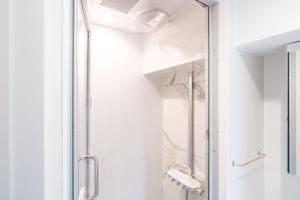 een douche met een glazen deur in een badkamer bij Shinsen Hombe BLD in Tokyo