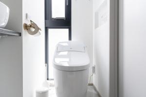 een wit toilet in een badkamer met een raam bij Shinsen Hombe BLD in Tokyo +19 foto's