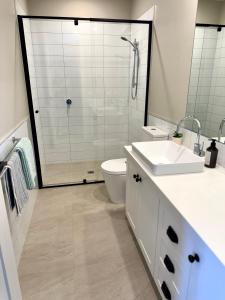 a bathroom with a shower and a toilet and a sink at Haven on Hunter Lux Townhouse in Mansfield
