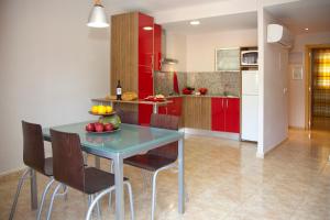 a kitchen with red cabinets and a table with fruit on it at Apartamentos Campuebla in Montanejos