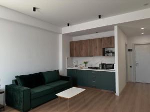 a living room with a green couch and a kitchen at Apartment #114 Gudauri, Redco Alpic in Gudauri +6 photos