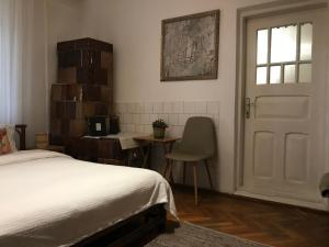a bedroom with a bed and a table and a chair at Casa de Vacanta Nora in Oveselu