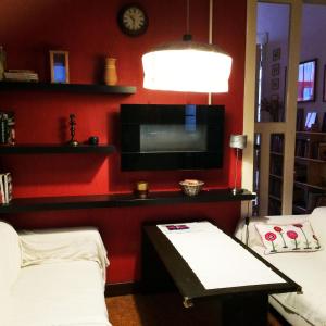 ブダペストにあるÁrgyélus Apartmentの赤い壁のリビングルーム(テーブル、テレビ付)
