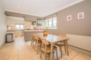 a kitchen with a wooden table and chairs at Central Cardiff Victorian Town House Free parking in Cardiff