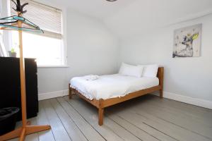 a bedroom with a bed with white sheets and a window at Central Cardiff Victorian Town House Free parking in Cardiff