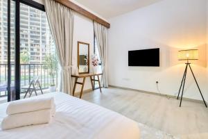 Un dormitorio blanco con una cama y una ventana grande. en Luxury Villa in Marbella RAK, en Ras al Khaimah