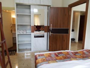 a room with a bedroom with a bed and a mirror at Kamadhenu Residency Homestay & Service Apartment Coorg Madikeri in Madikeri