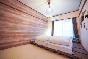 a bedroom with two beds and a wooden wall at Route99 Yumoto 箱根湯本駅近山沿い川沿い 箱根湯本徒歩8分WIFI 大人気ゲーム機無料 最大6名 無料駐車場 in Hakone