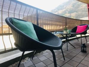 two chairs and a table on a balcony at Route99 Yumoto 箱根湯本駅近山沿い川沿い 箱根湯本徒歩8分WIFI 大人気ゲーム機無料 最大6名 無料駐車場 in Hakone +42 photos