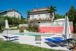 a villa with a swimming pool and two lawn chairs at Cluana Azienda Agrituristica in SantʼElpidio a Mare