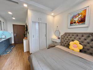 - une chambre avec un grand lit et une tête de lit ornée d'une fleur jaune dans l'établissement Vinhomes Greenbay Me Tri - Luxury, Garden Apartment in Hanoi, à Hanoï 32 autres photos