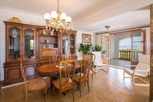 a dining room with a table and chairs and a chandelier at Na Penyal in Cala Millor