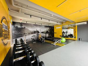 a gym with black chairs and a yellow wall at Youth City Residence in Nilai
