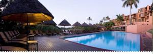 a swimming pool with chairs and umbrellas in a resort at San Lameer Villas Three Bedroom --&-- Two Bedroom in Southbroom