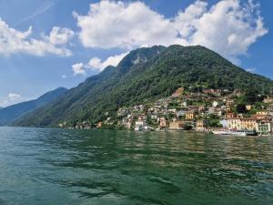 a town on a hill next to a body of water at Casa Hygge Argegno Lago di Como in Argegno
