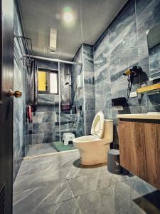 a bathroom with a toilet and a shower at Peninsula Travel B&B in Hengchun