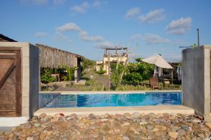 a swimming pool in front of a house at Tres Velas Surf in Celestino Gasca