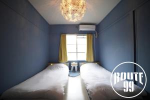 箱根Hakone 8mins walk-modern style FreeNetflix Switch - Unit 204的一间卧室设有两张床和一个带吊灯的窗户。