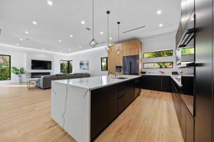 an open kitchen and living room with black and white at Heated Pool & Rooftop Near Intracoastal in Boynton Beach