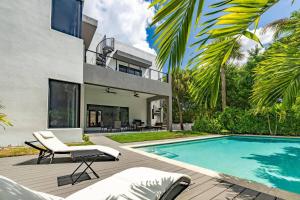 an exterior view of a house with a swimming pool at Heated Pool & Rooftop Near Intracoastal in Boynton Beach