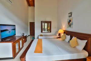 - une chambre avec un grand lit blanc et une télévision à écran plat dans l'établissement Grand Kalundawa Resort, à Dambulla 26 autres photos