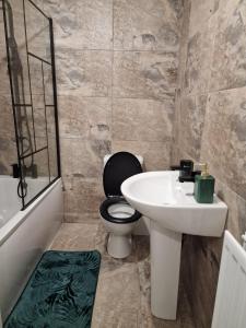 a bathroom with a toilet and a sink at Entire 3 bedroom luxurious house, Wigan , Manchester in Wigan +21 photos
