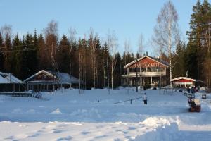 a person standing in the snow in front of a lodge at Hotel Rantakatti in Punkaharju