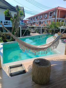 a hammock in front of a swimming pool at Haadrin village Fullmoon in Haad Rin