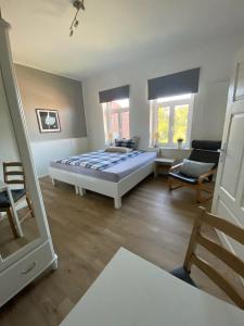 a large bedroom with a bed and a chair at Pension Grunwald in Sehnde