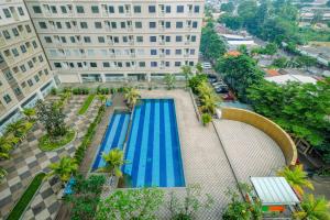 an overhead view of a swimming pool in front of a building at Minimalist and Comfy 2BR at Titanium Square Apartment By Travelio in Jakarta