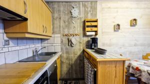 a kitchen with wooden cabinets and a sink at Résidence Sagittaire - Appartement rénové avec balcon · Centre station MAE-7398 in Flaine