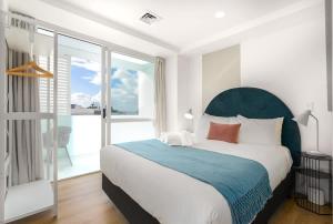 a bedroom with a large bed and a large window at Tasteful Luxury Modern 2BR with Aircon in the City Next to Albert Park in Auckland