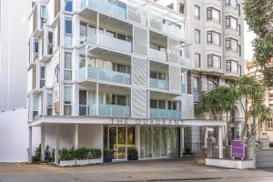 an apartment building with a sign that reads the quaternary at Tasteful Luxury Modern 2BR with Aircon in the City Next to Albert Park in Auckland