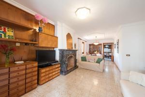 sala de estar con TV y chimenea en Villa Vallespir, en Puerto de Alcudia