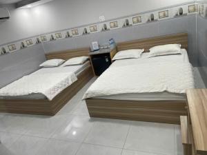 two twin beds in a room with at Moony Hotel Long Thành in Long Thành