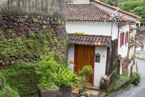 een stenen huis met een bruine deur in een straat bij Pouso da Passagem B&B in Mariana