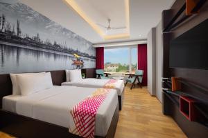 una camera da letto con due letti e una TV a schermo piatto di Ginger Srinagar Barzulla Near Srinagar Airport a Srinagar