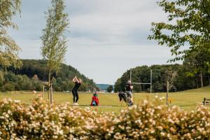 a group of people and a dog in a field at Holma Stångenäs Golf in Brastad