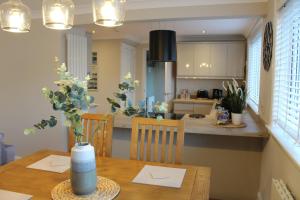 a kitchen and dining room with a table with a vase on it at Lovely Riverside Holiday Home in Callander