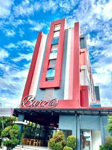 a red and white building with a sign on it at Burza Hotel Lubuk Linggau in Lubuklinggau