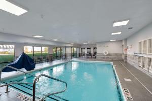 a large swimming pool with chairs and tables in a building at Hampton Inn Bloomington West in Bloomington