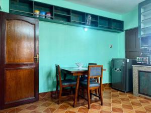 a kitchen with a table and chairs and a refrigerator at Private Couple Apartment in Kathmandu