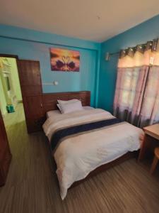 a bedroom with a large bed with blue walls at Private Couple Apartment in Kathmandu