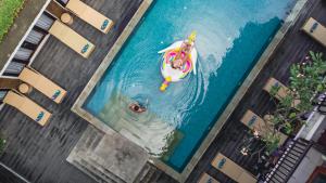 an overhead view of two people swimming in a pool at The Kirana Canggu Hotel in Canggu +25 photos