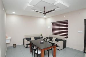 a living room with a table and chairs at Eagle Nest Residency in Perintalmanna