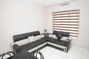 a living room with a black and white couch at Eagle Nest Residency in Perintalmanna
