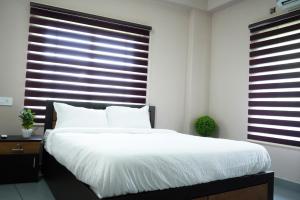 a bedroom with a large bed and a large window at Eagle Nest Residency in Perintalmanna